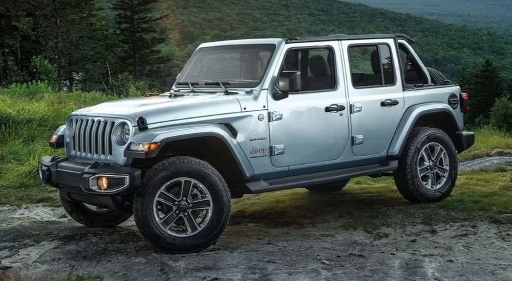 A silver 2024 Jeep Wrangler Sahara Unlimited is shown parked on rock after leaving a Jeep dealer.