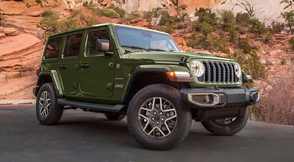 A green 2024 Wrangler Sahara Unlimited is shown parked on pavement.