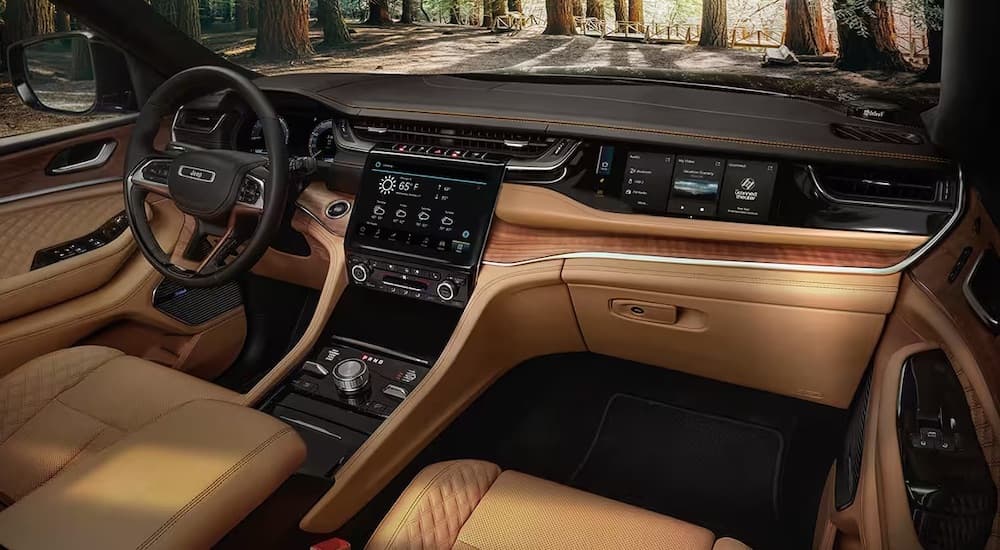 The brown interior of a 2024 Jeep Grand Cherokee is shown from the passenger seat.